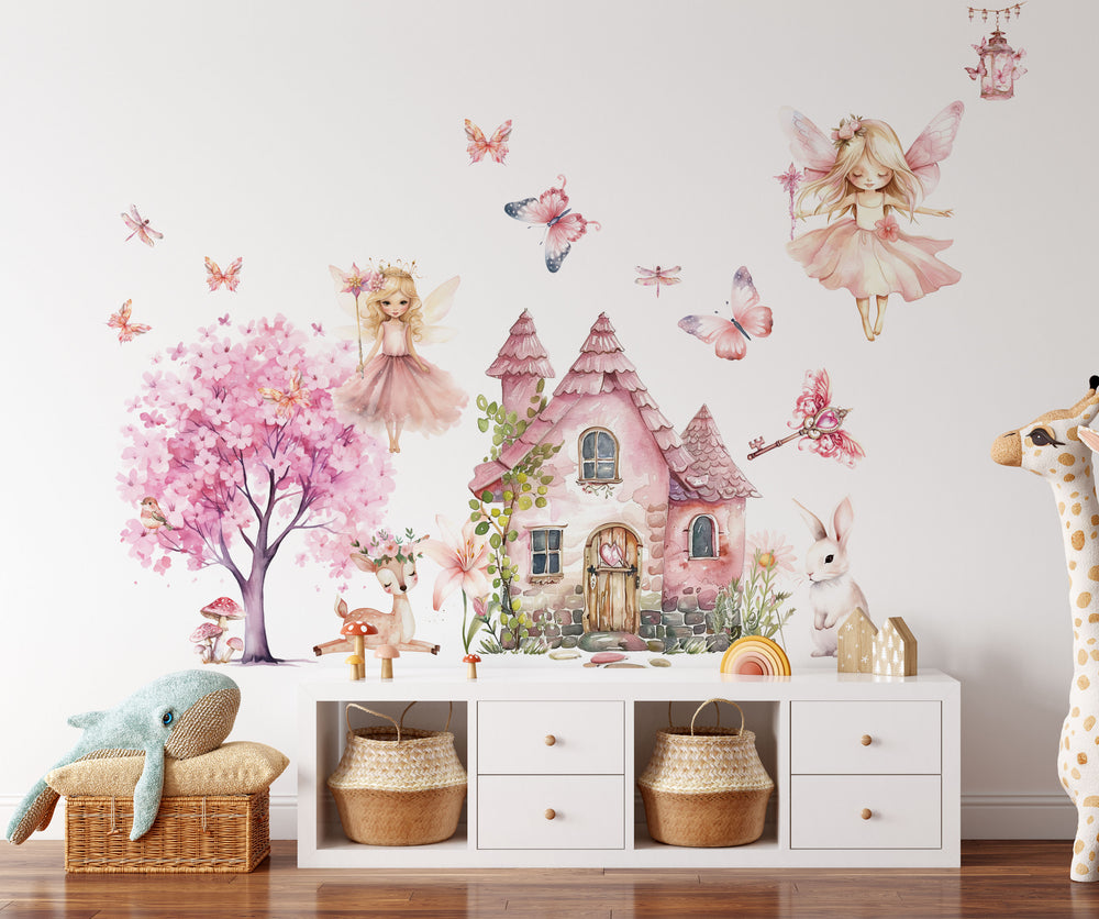 Watercolor fairy wall decals with cute magical fairies in pink dresses and butterflies decorating a cozy girls bedroom wall.
