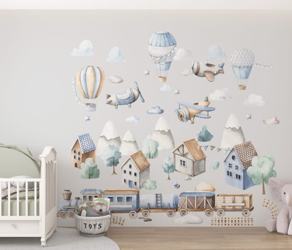 Hot air balloons, airplanes and a train wall stickers arranged across a child's room wall in pastel colours