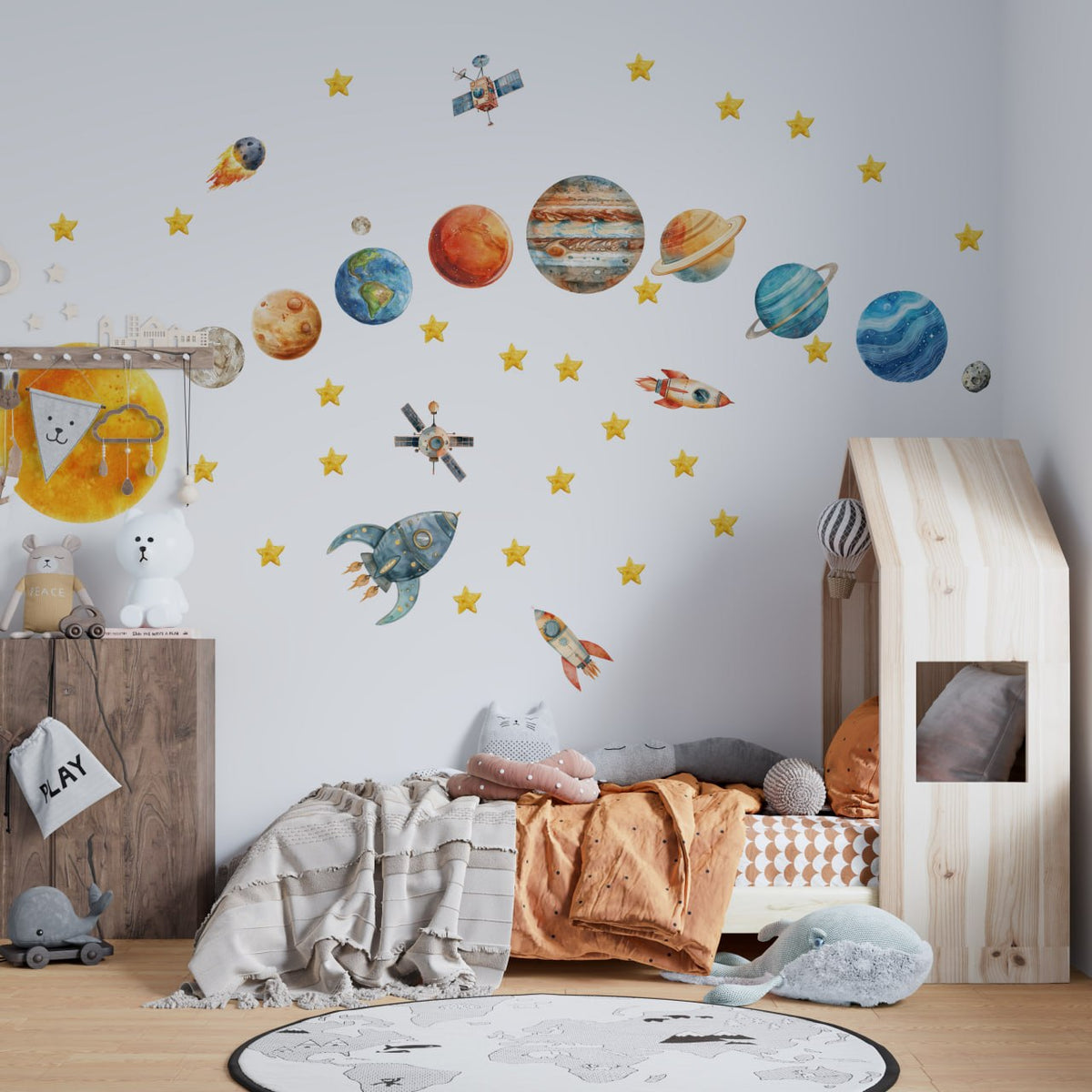 Solar system wall decals with planets and rockets above a house-frame bed in a child's room by Igibee
